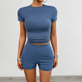 Women's solid colour slim fit sports suit set with short sleeve t-shirt and elastic waist shorts.