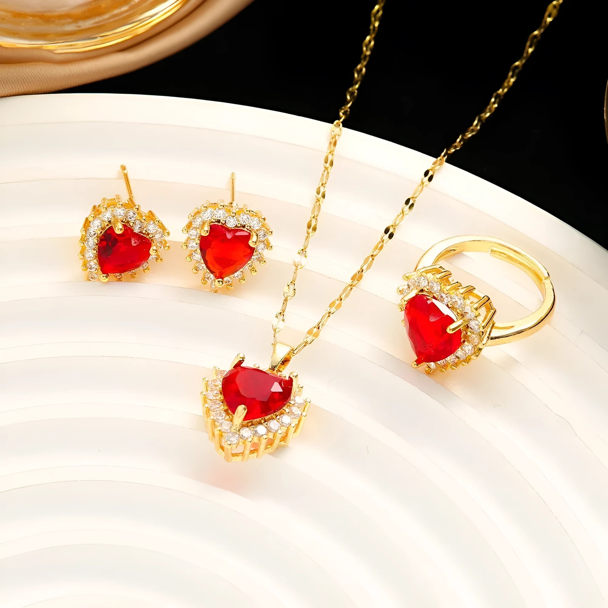 Gold-red titanium steel necklace and earrings set with heart-shaped flower pendant and gemstone detail.