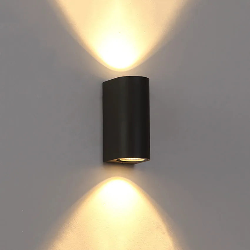 Satin black aluminium and glass LED wall lamp mounted on an interior wall.