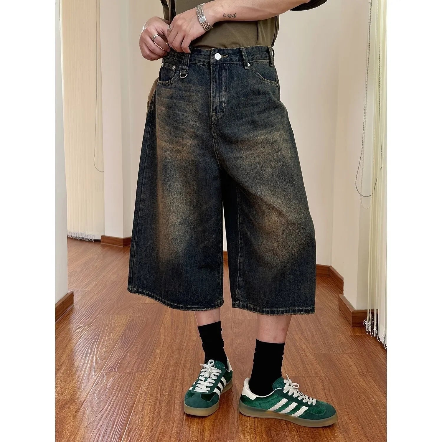Man wearing blue loose straight-leg denim shorts with a simple summer style.