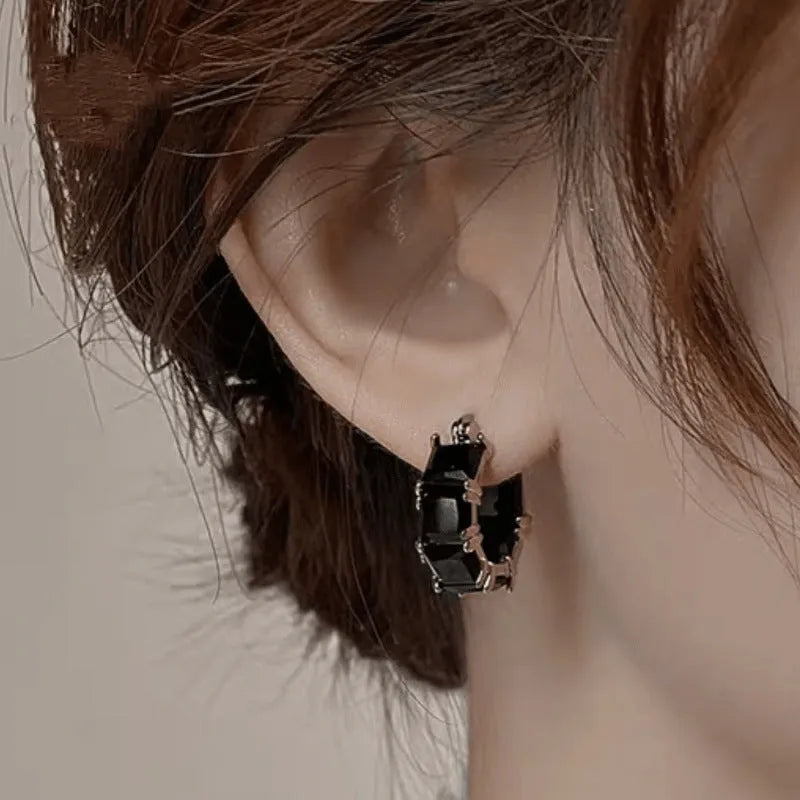 Gold geometric U-shaped women's earrings with a round black zircon stone.