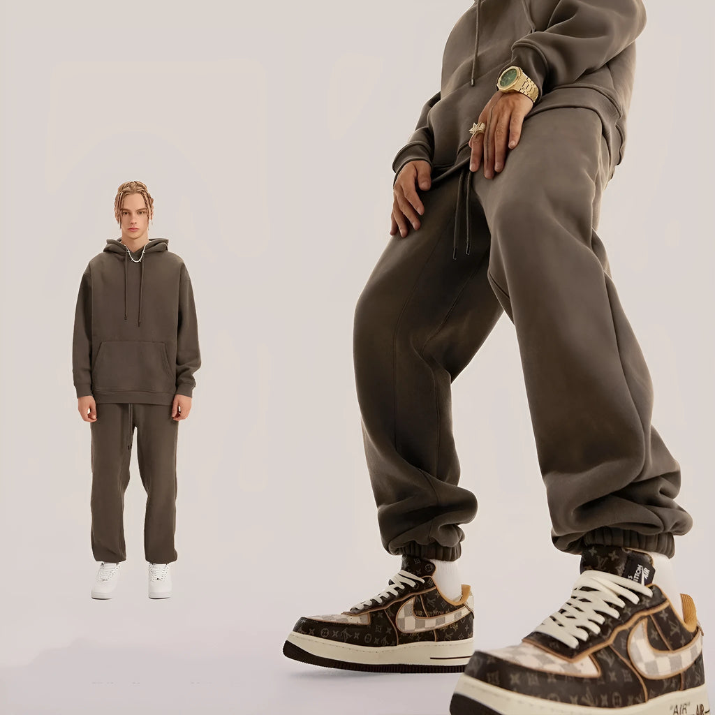 Man wearing dark brown velvet sweatpants with an ankle band and elastic waist.