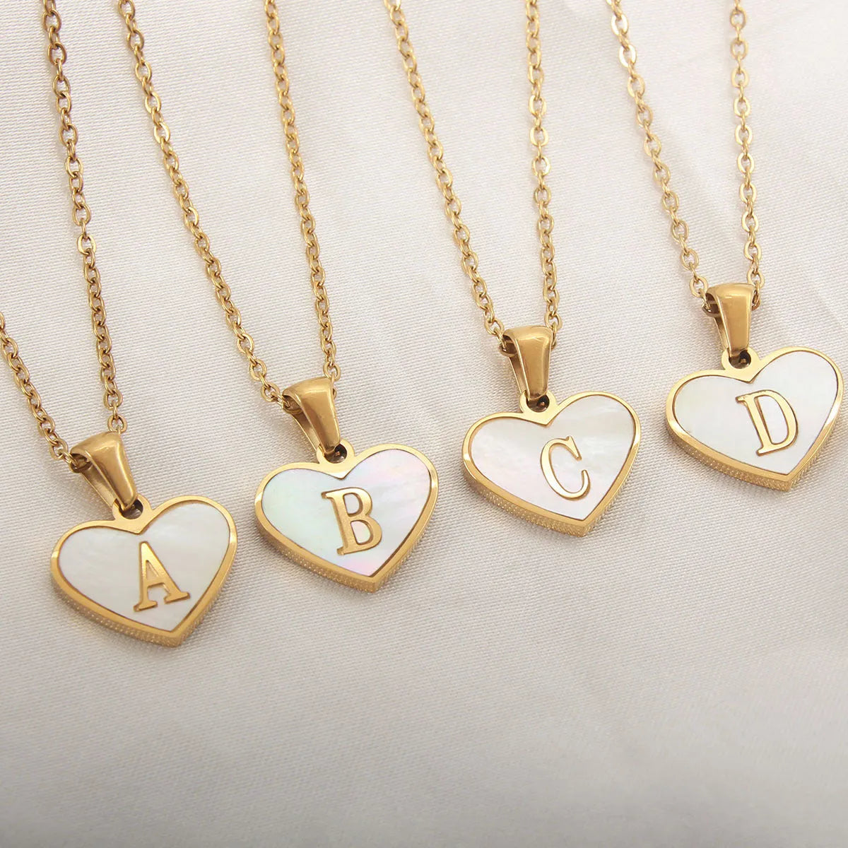 Gold plated heart pendant necklace with white shell centre on a stainless steel chain.