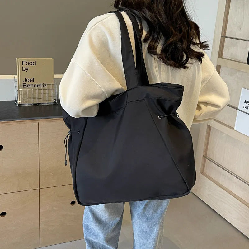 Soft Oxford cloth commuter tote bag in a street style, shown in a folded position.