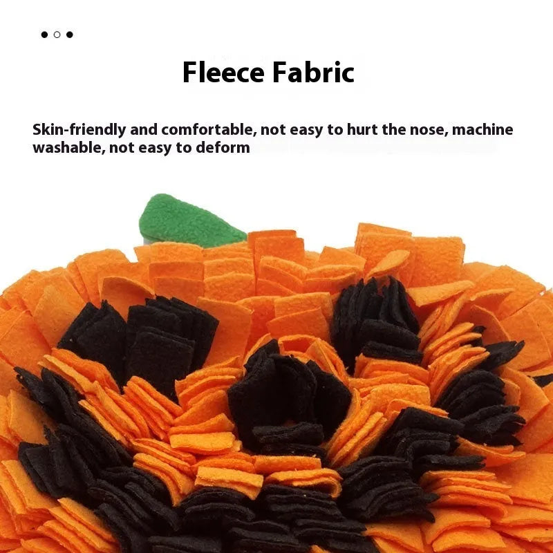 Orange pumpkin-shaped pet slow feeder mat on floor with scattered kibble