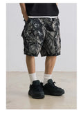 Man's loose straight-leg denim shorts in black on a hanger, showing mid-rise waist and zip fly.