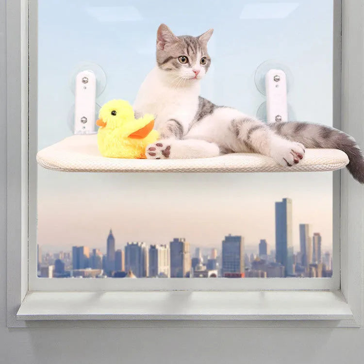 Foldable cat hammock with stainless steel suction cups mounted on a window, shown in grey plush fabric.