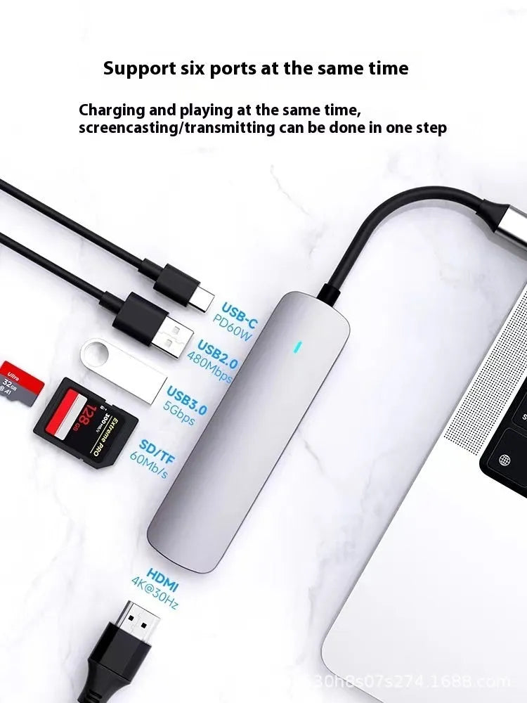 USB-C 7-in-1 expansion dock with HDMI port, USB 3.0 ports, and card readers connected to laptop