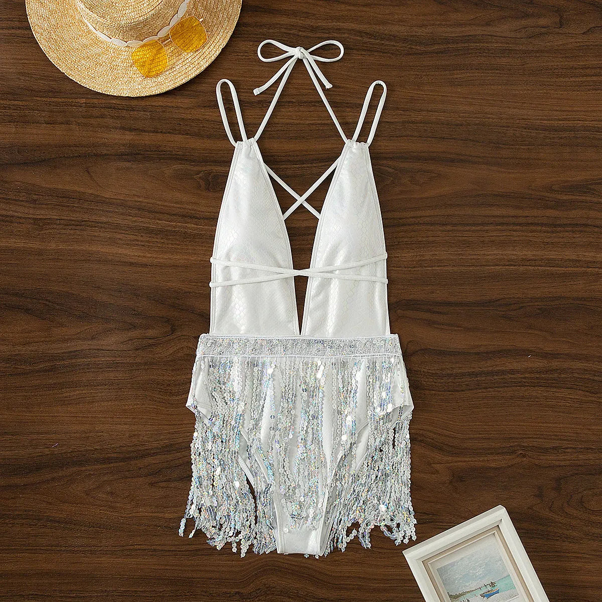 White women's one-piece swimsuit with deep V-neckline and tassels, sleeveless briefs style.