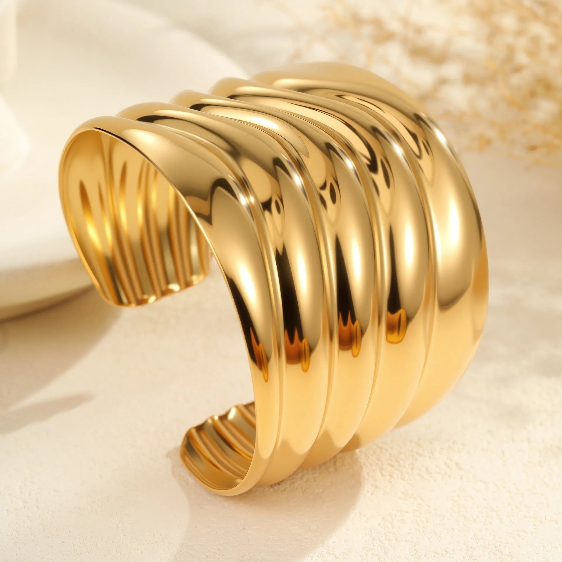 Gold plated stainless steel wide bracelet for women with geometric wave design and niche opening clasp
