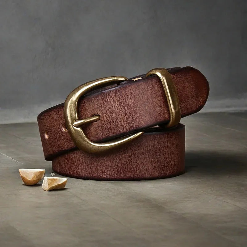 Men's brown casual leather belt with copper pin buckle on a jeans background.