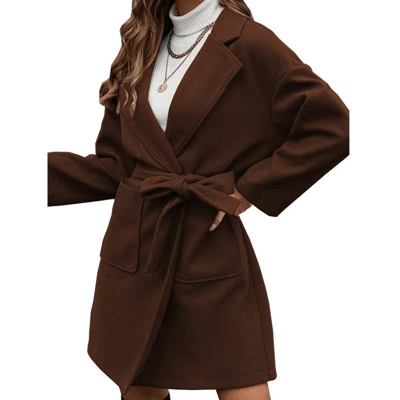 Minimalist loose fit long sleeve coat with lapel buttons and a split belt in a light blue colour.