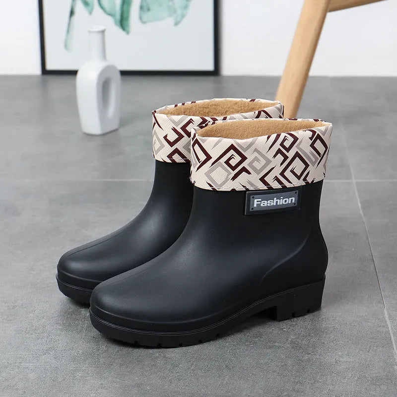 Women's mid-calf PVC rain boot in black with a low heel on a white background.