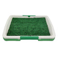 Green synthetic turf dog toilet trainer with three-layer plastic tray system for indoor use.