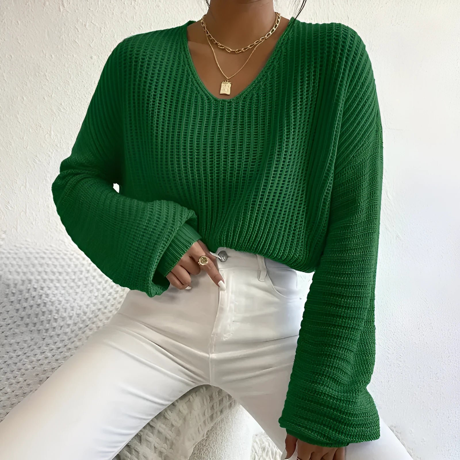A woman wearing a solid colour long sleeve pullover in a loose, casual fit.