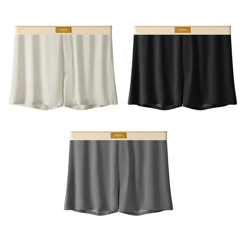 Pack of three men's solid colour loose fit ice silk underwear briefs on a grey background.