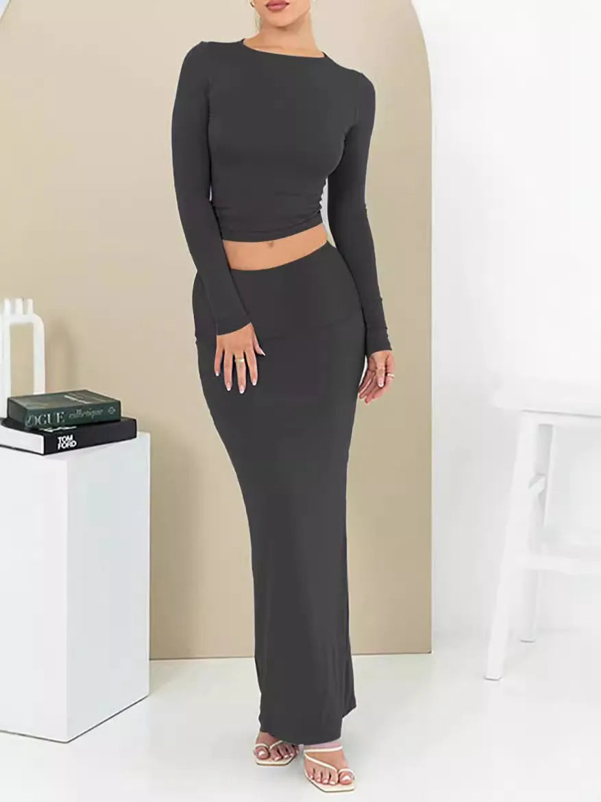 Women's black slim fit two-piece suit set with three-quarter sleeve top and long skirt on a model.