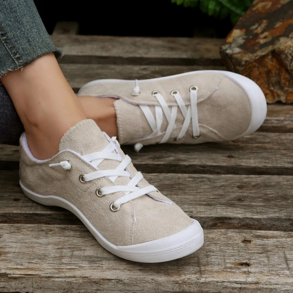 Women's creamy-white fabric casual sneakers with rubber soles shown in low-top design