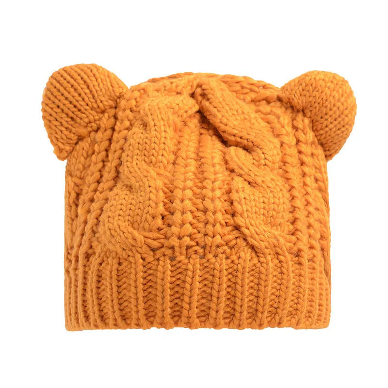 Handmade red knitted beanie with 3D cat ears on a white background.