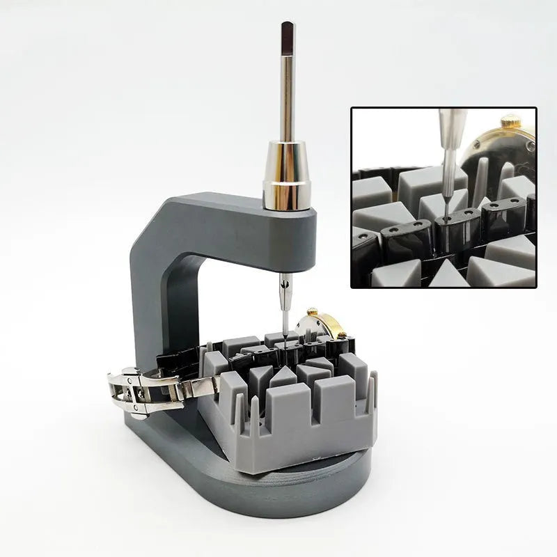 Silver coloured tool steel press strap removal tool for watch and jewellery repair on a dark surface.