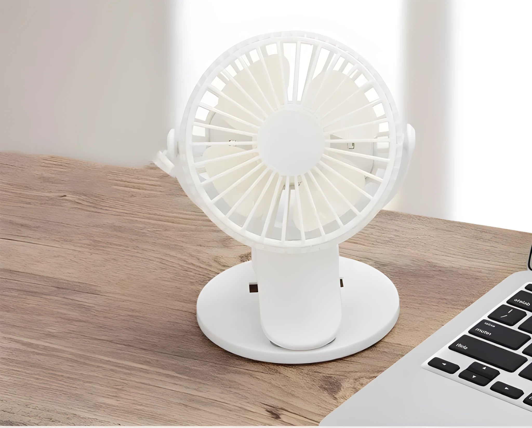 White USB clip fan with plastic blades mounted on desk edge showing piano button switch