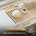 Milky white foldable stainless steel kitchen draining rack next to a sink.