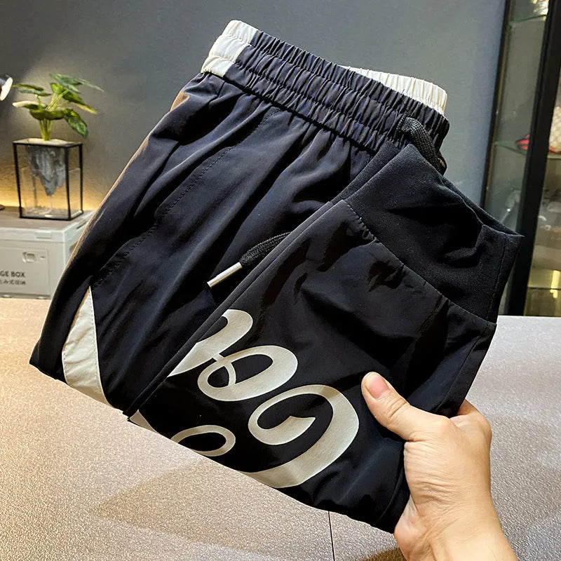 Men's solid black cotton cropped trousers with ankle banded style on hanger