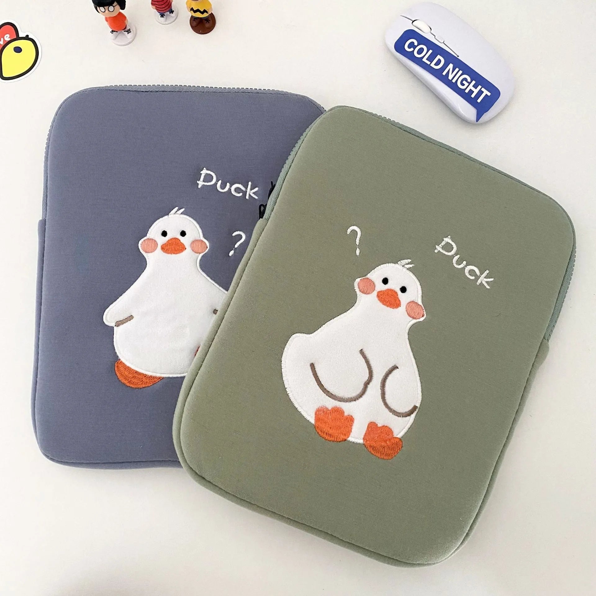 Blue cotton tablet case with embroidered cartoon duck design and a zipper.