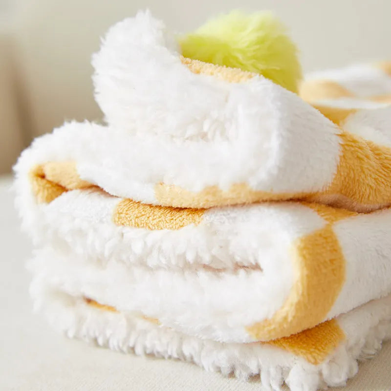Plush pet blanket with plaid pattern and decorative fur ball in green colour
