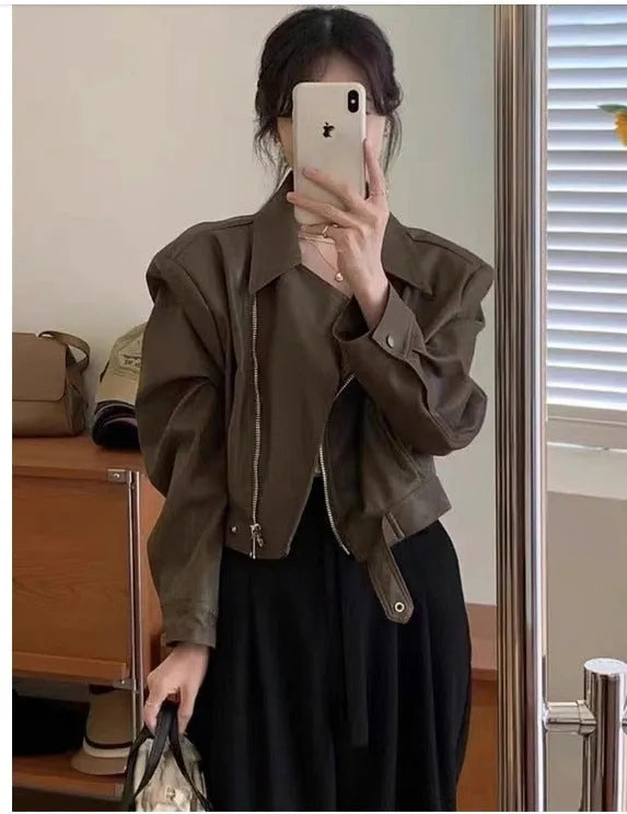 Women's slim-fit short brown retro leather jacket with long sleeves and a pocket.