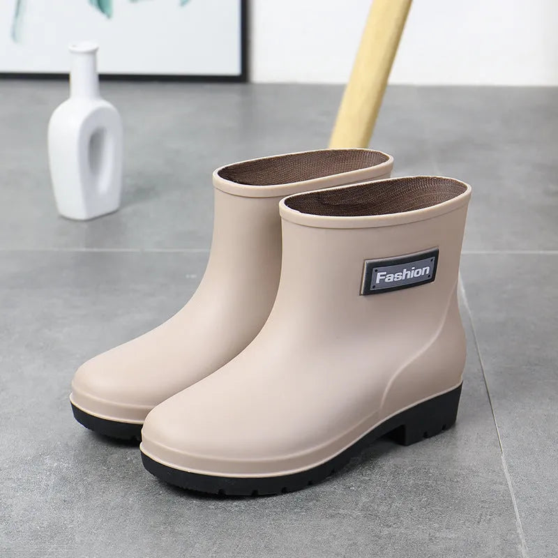 Women's mid-calf PVC rain boot in black with a low heel on a white background.