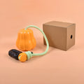 Orange plastic pumpkin dog toy with attached rope for outdoor fetch games