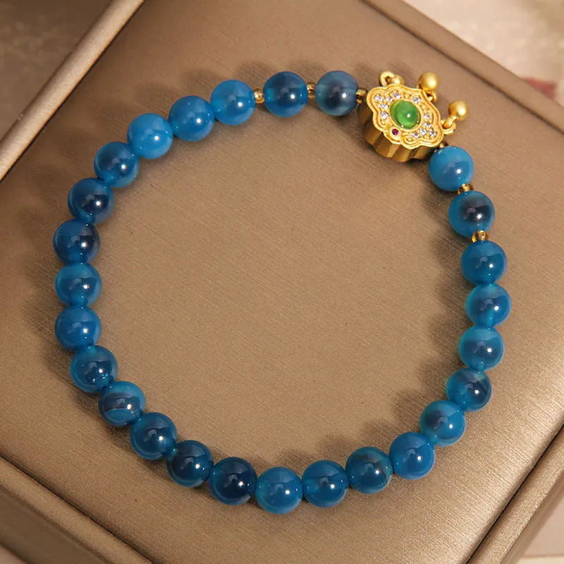 Blue sugar heart agate safety lock pendant on a crystal women's bracelet with rhinestone details.