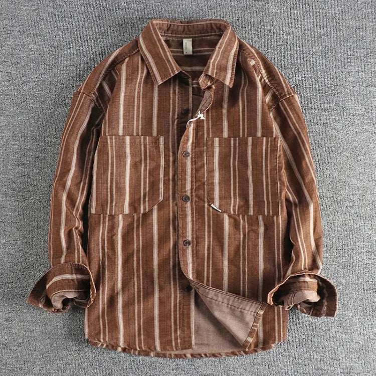 Man wearing a vintage-style striped overalls shirt in apricot colour with long sleeves and loose fit.