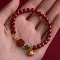 Chinese cinnabar bracelet with emperor sandstone beads and a carved fu character symbol.