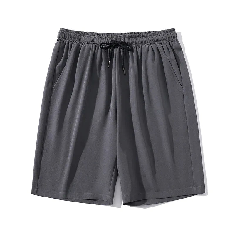 Man wearing grey cropped nylon sports pants with straight leg for summer beach activity
