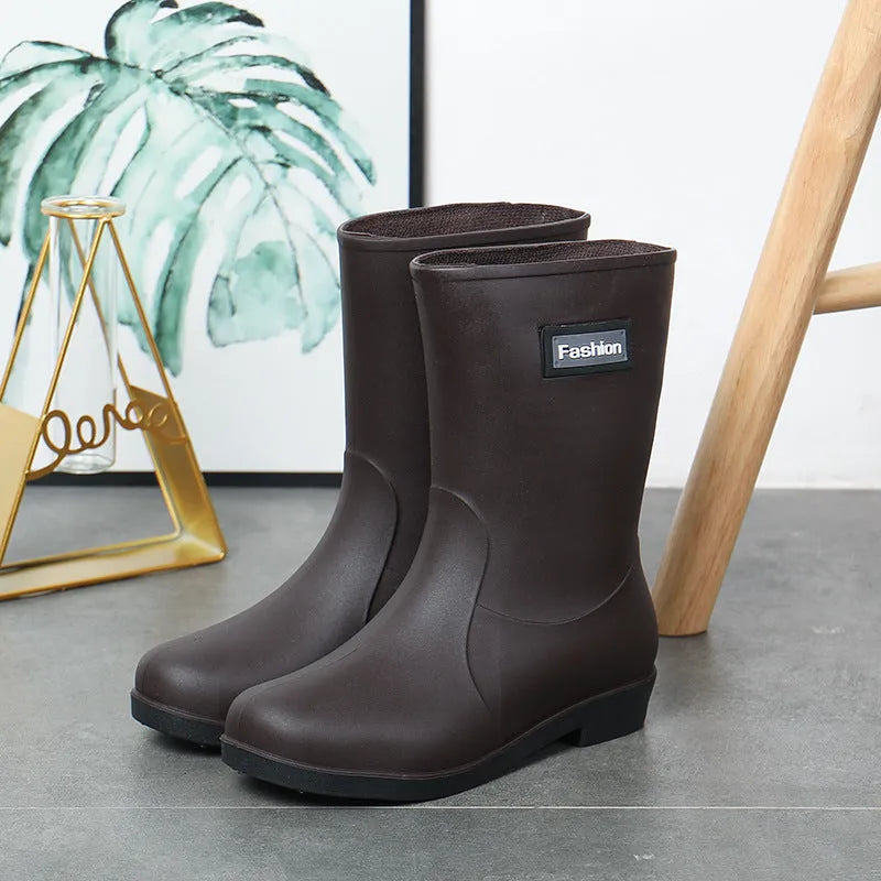Women's mid-calf PVC rain boot in black with a low heel on a white background.