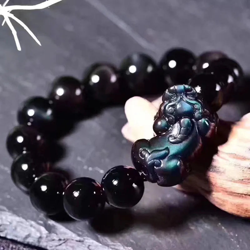 Natural ice colour eye obsidian crystal bracelet on a wrist, showing bead detail.