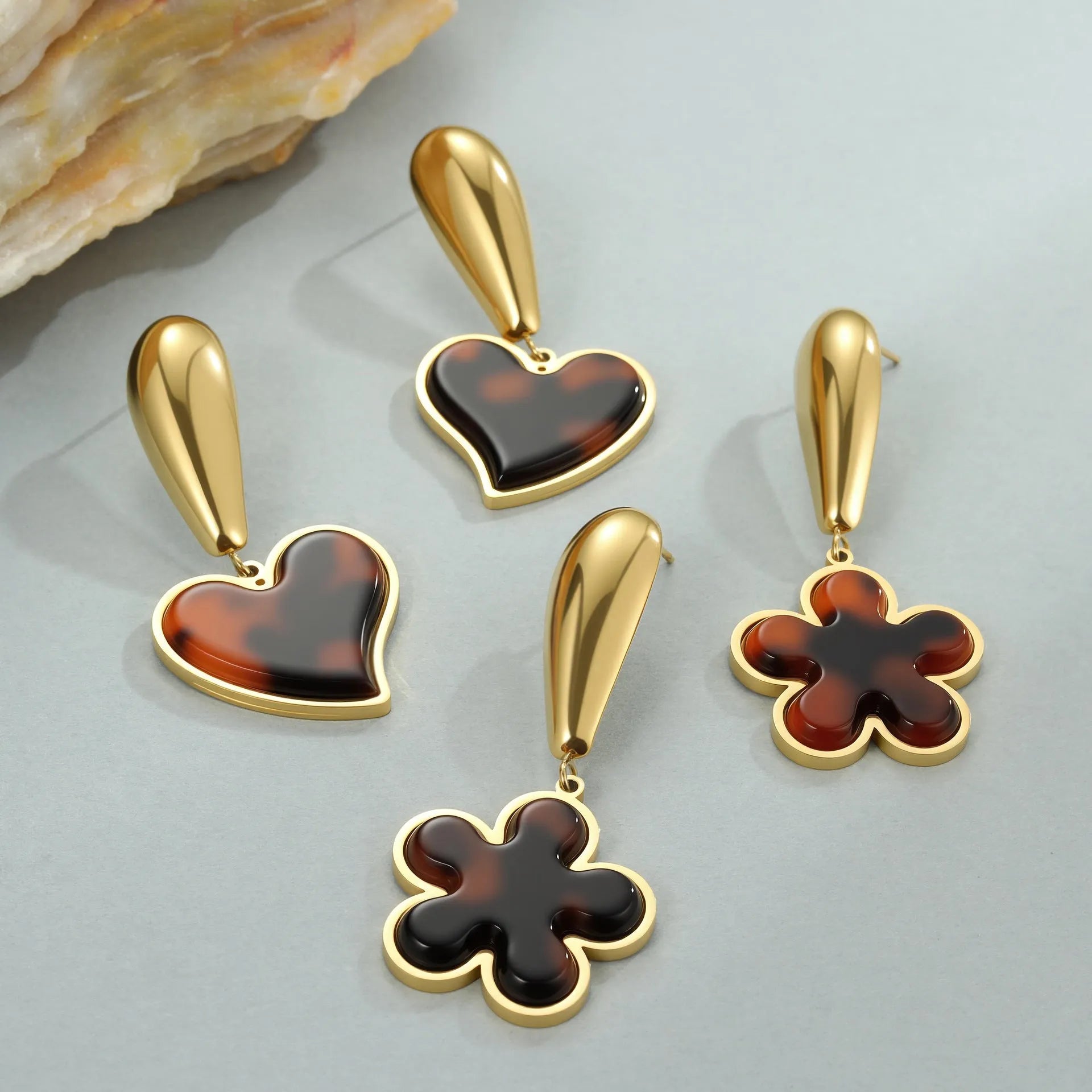 Women's tortoiseshell resin earrings in hawksbill colour with 18K gold plating showing heart and flower geometric designs