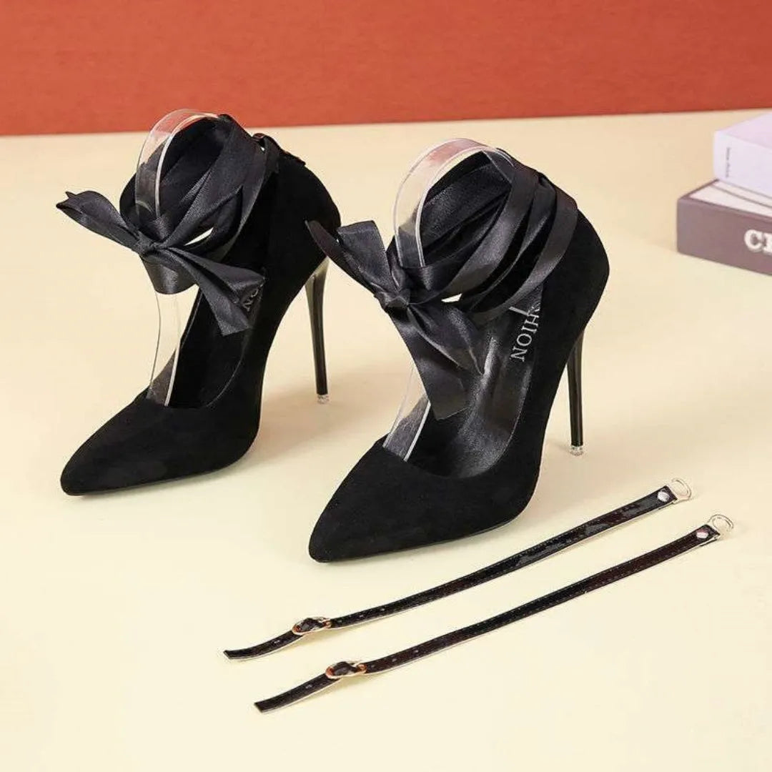 Black pointed toe high heel pump with a lace strap across the foot on a 12cm heel.