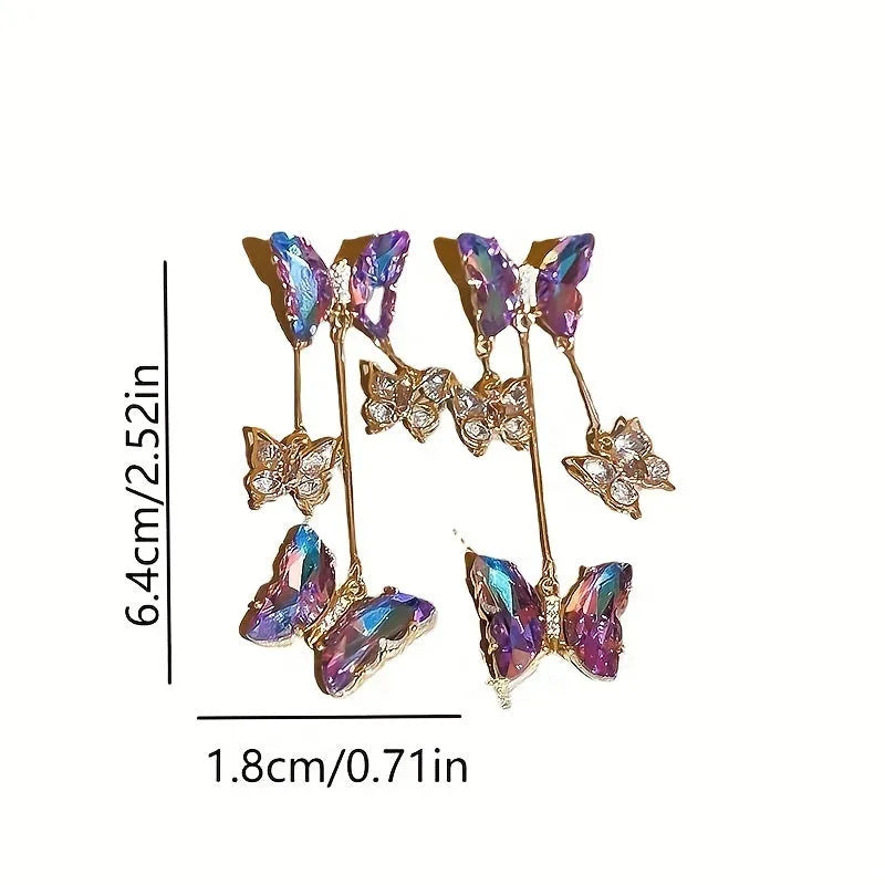 Silver needle style drop earrings with blue purple butterfly, crystals, and a tassel.