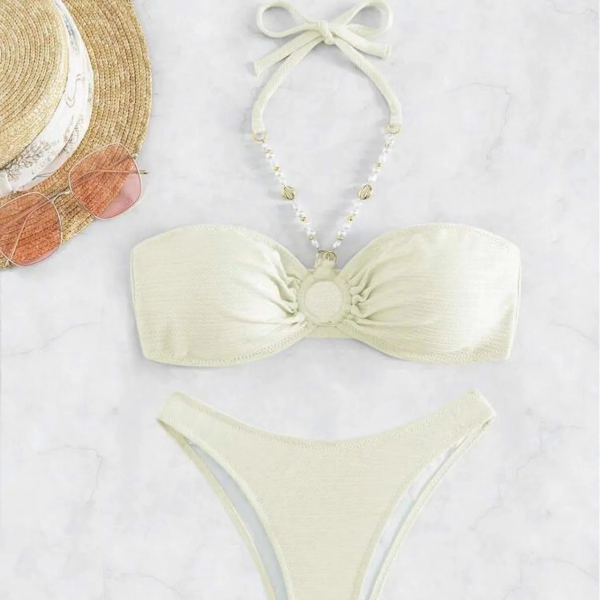 Women's creamy-white halter top and briefs bikini set for swimming on a beach