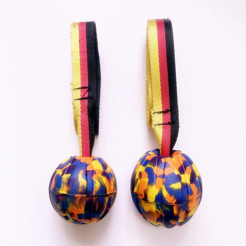 Yellow and camouflage floating EVA foam dog balls with tether strings in three different sizes on a blue background.