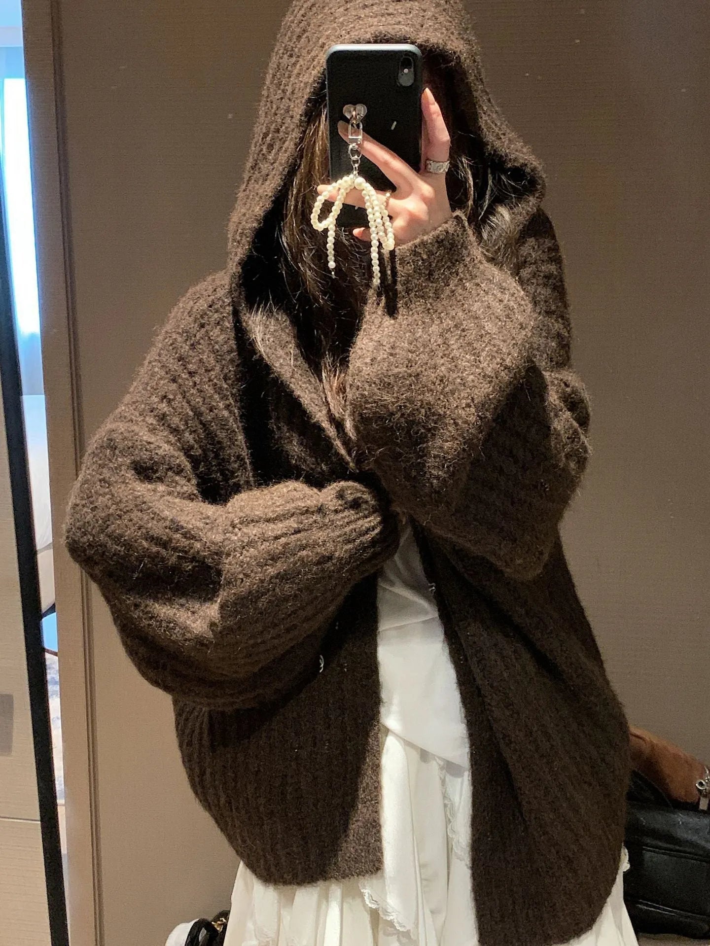 A woman's dark grey hooded cardigan with long sleeves, shown open in a loose fit.