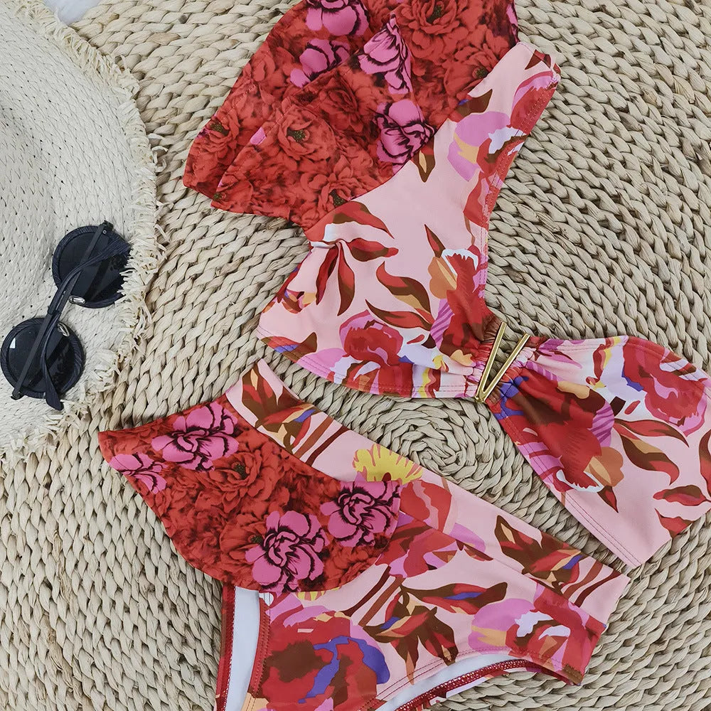 Women's pink floral print one-shoulder bikini with ruffle trim and high-waisted split briefs.