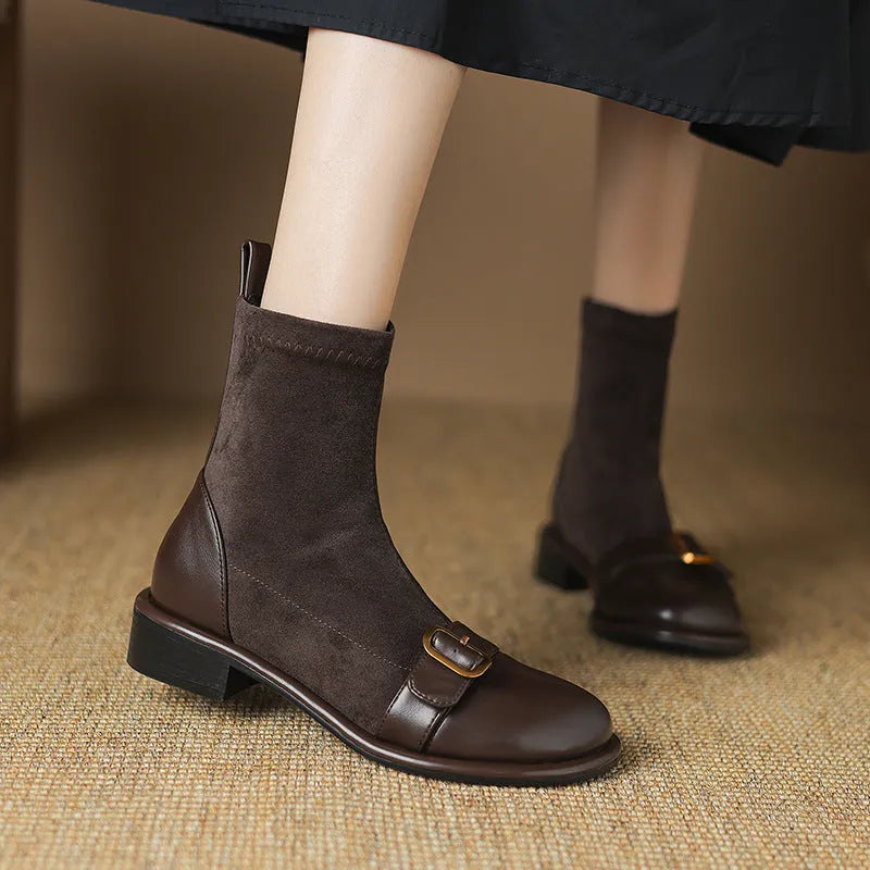 Women's black low-heel Martin boots with belt buckle detail and front lace-up fastening.