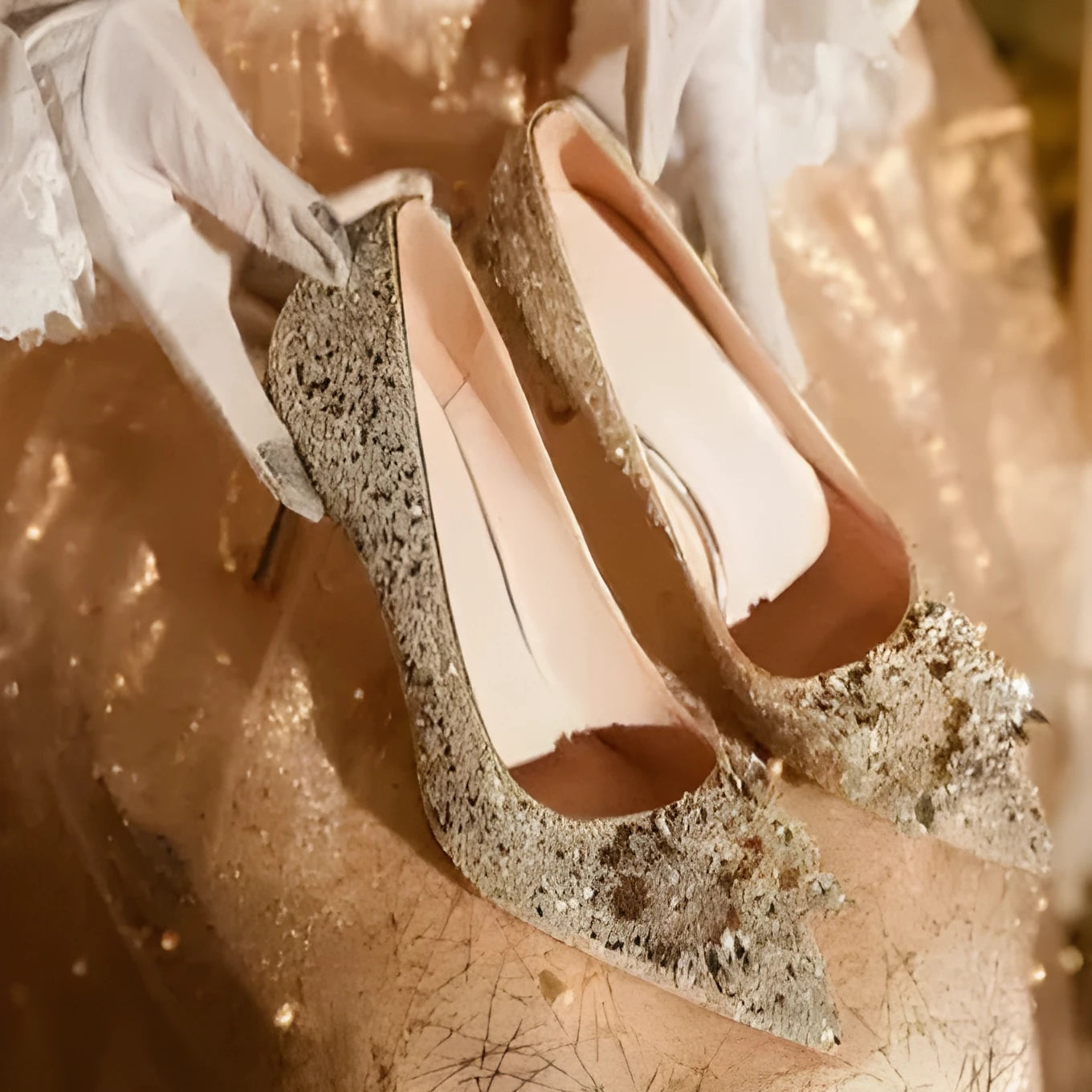 Champagne pointed-toe women's bridal shoes with floral rhinestone detail on a white background
