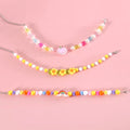 Colourful plastic bead pet necklace in peach, rainbow, or small flower patterns with adjustable sizing.