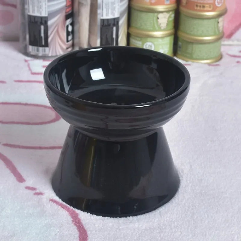 Black ceramic pet bowl with a chin-high foot and raised neck protector on a white background.