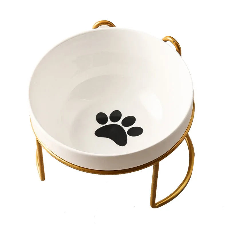 White ceramic cat bowl with decorative pattern sitting in a black iron frame stand.